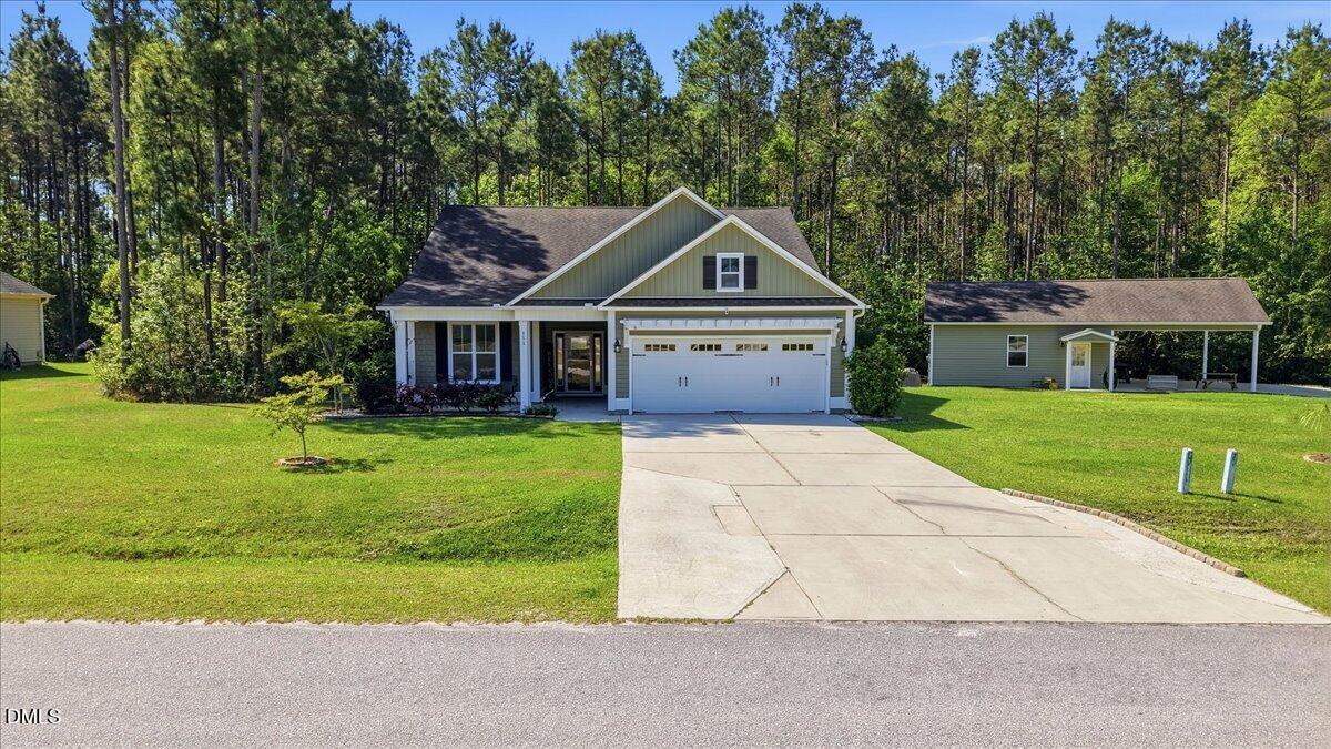 111 West Huckleberry Way Rocky Point, NC 28457 - Photo 19 of 72 a front view of a house with a garden and trees