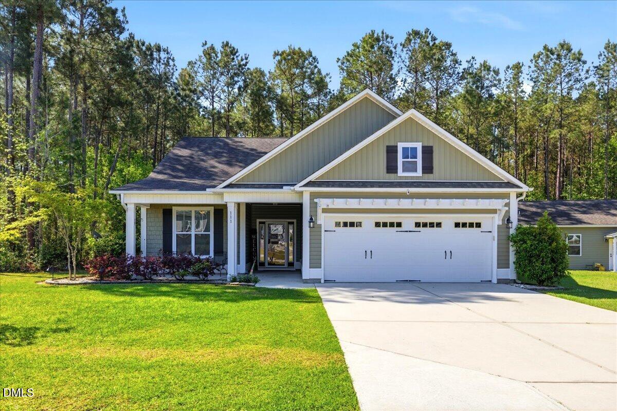 111 West Huckleberry Way Rocky Point, NC 28457 - Photo 2 of 72 a view of a house with a yard potted plants and a large tree