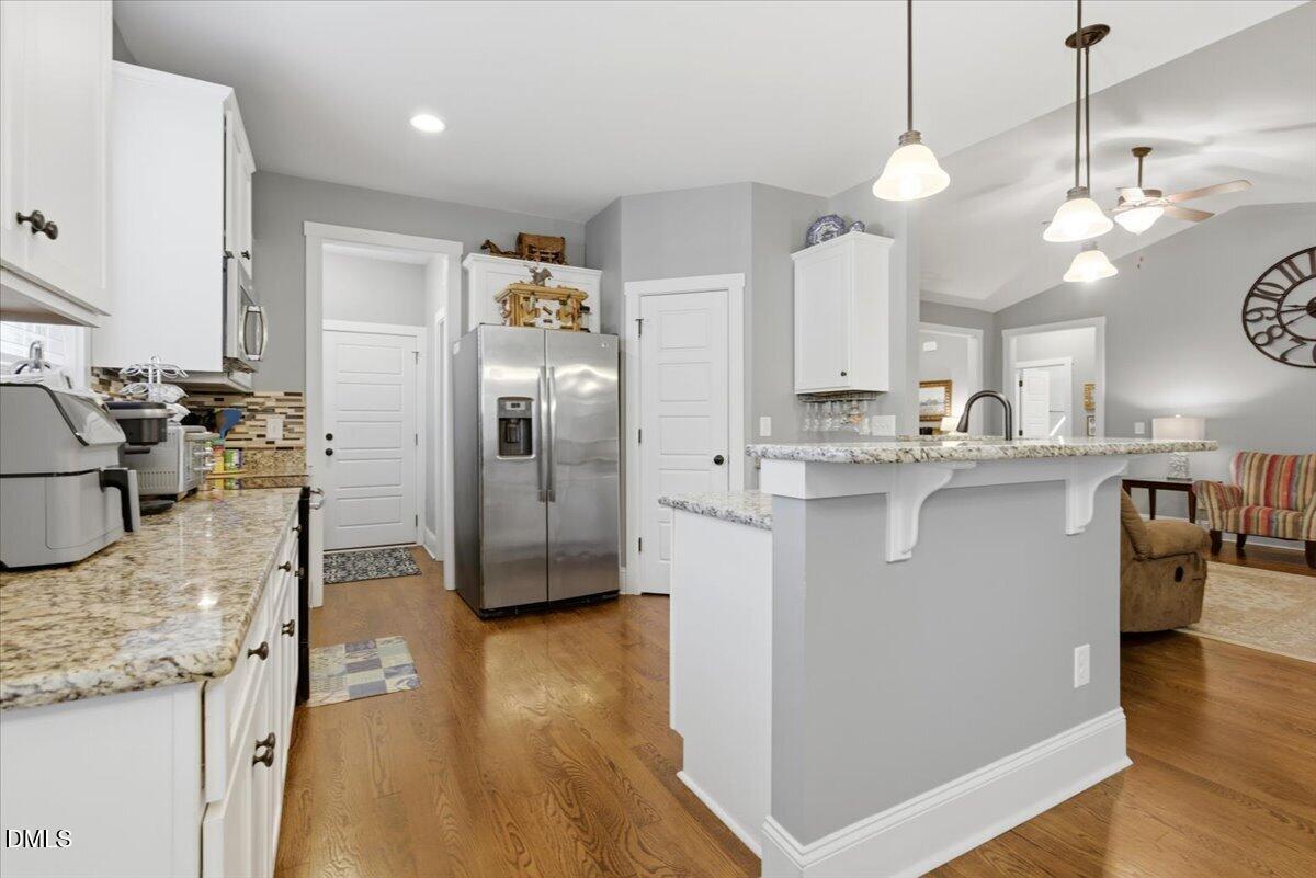 111 West Huckleberry Way Rocky Point, NC 28457 - Photo 39 of 72 a kitchen with stainless steel appliances granite countertop a sink a stove and a wooden floors