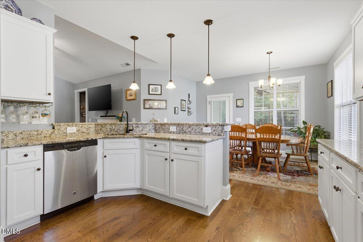 111 West Huckleberry Way Rocky Point, NC 28457 - Photo 42 of 72 a open kitchen with granite countertop a stove a sink a dining table and chairs with wooden floor