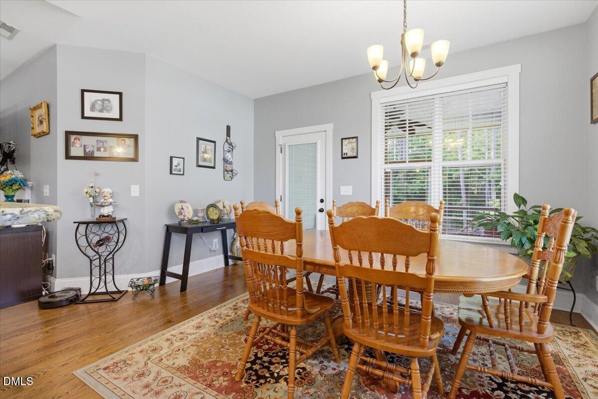 111 West Huckleberry Way Rocky Point, NC 28457 - Photo 45 of 72 a view of a dining room with furniture a chandelier and wooden floor