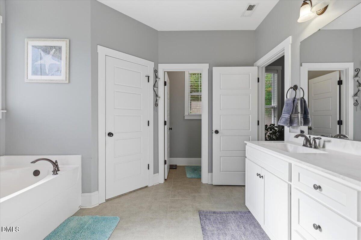111 West Huckleberry Way Rocky Point, NC 28457 - Photo 49 of 72 a spacious bathroom with a tub sink and mirror