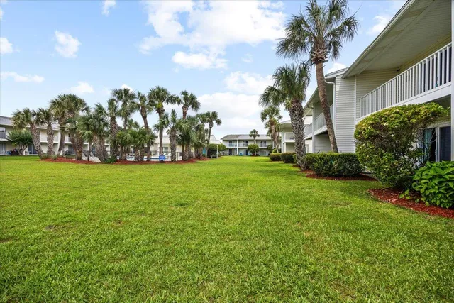 a view of a building with a yard and palm trees