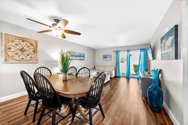 a view of a a dining room with furniture window and wooden floor