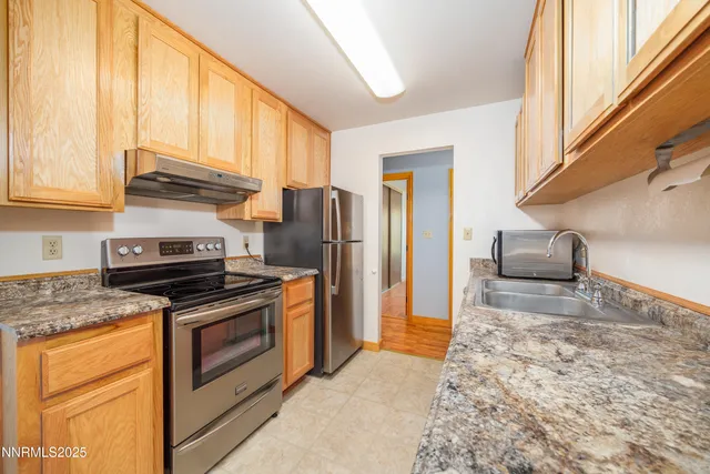 a kitchen with stainless steel appliances granite countertop a stove a refrigerator and a sink