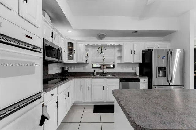 a large white kitchen with cabinets