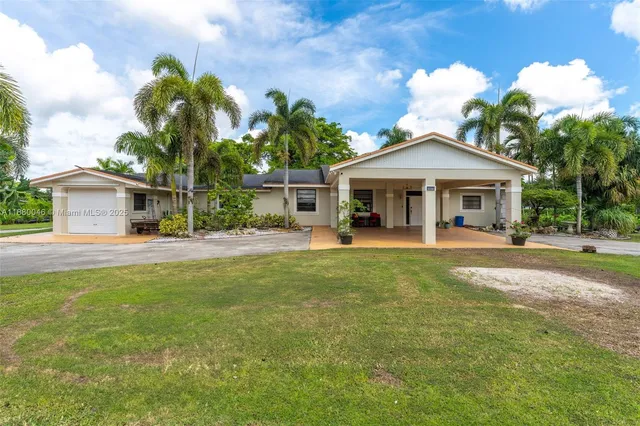 a view of a house with swimming pool and a yard