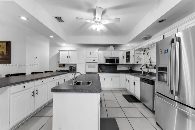 a kitchen with a sink counter top space appliances and cabinets
