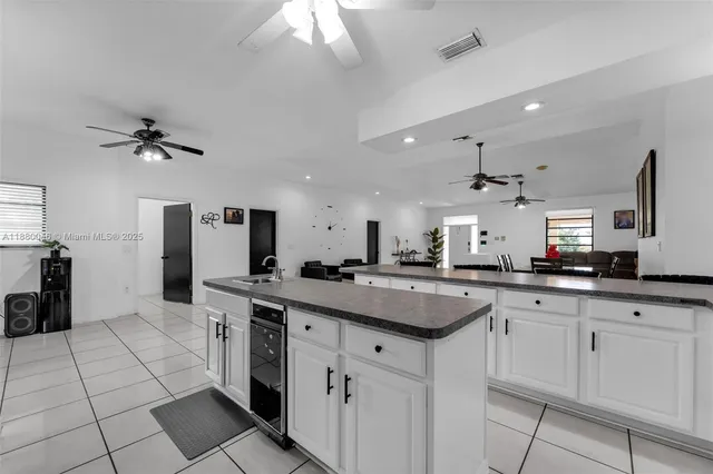 a kitchen with granite countertop a sink stainless steel appliances and white cabinets