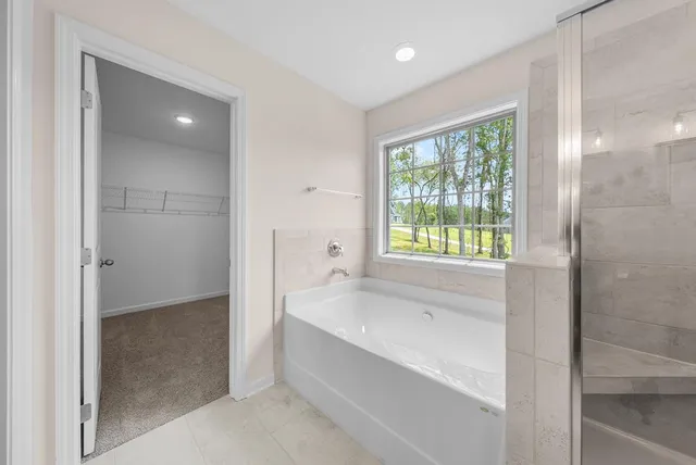 a spacious bathroom with a tub shower and sink