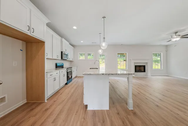a large kitchen with cabinets wooden floor and stainless steel appliances
