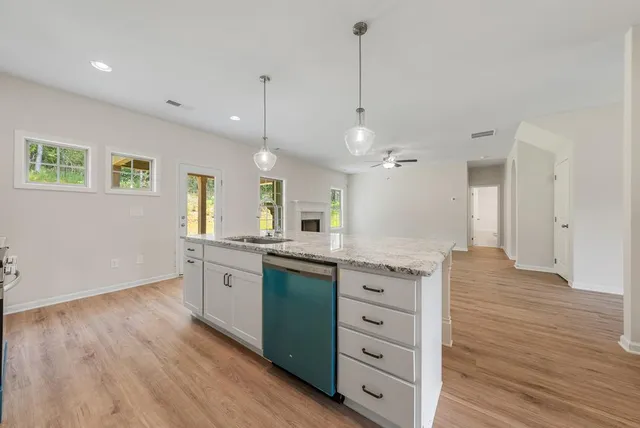 a large kitchen with granite countertop a lot of counter space and wooden floor