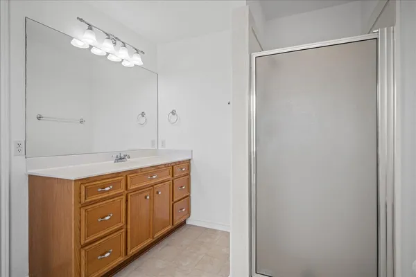 a bathroom with a granite countertop sink a large mirror and a shower