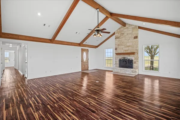 a view of empty room with wooden floor and fireplace