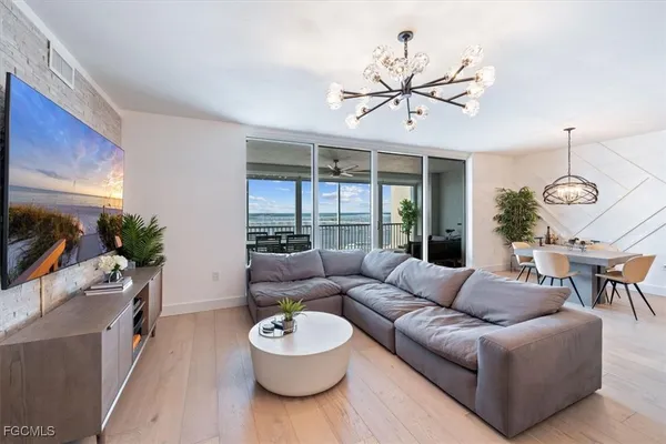 a living room with furniture a chandelier and a wooden floor