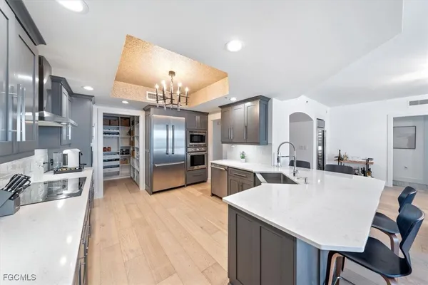 a large kitchen with kitchen island a sink stainless steel appliances and cabinets