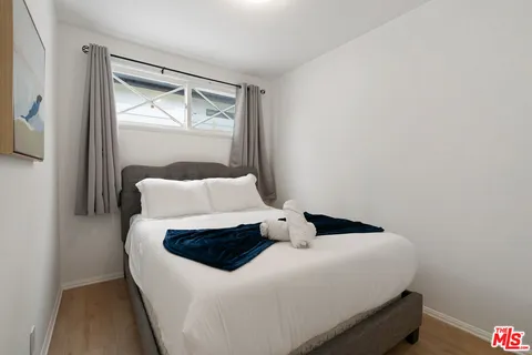 a bedroom with a bed and wooden floor