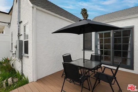 a patio with table and chairs and potted plants