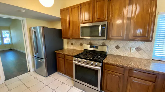 a kitchen with stainless steel appliances granite countertop a refrigerator stove and microwave