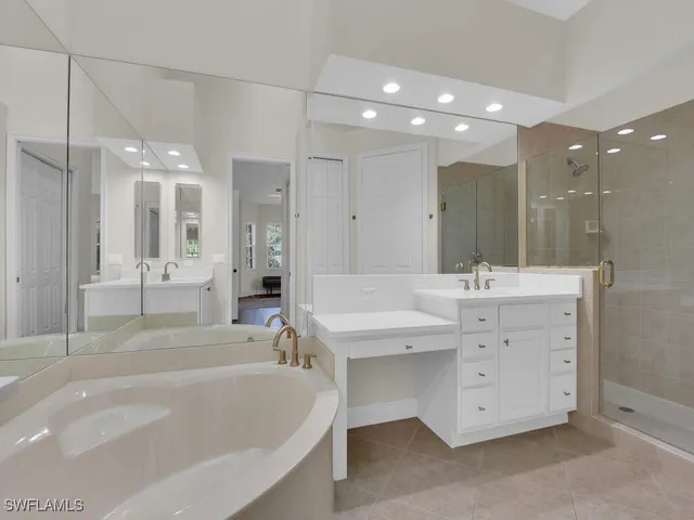 a bathroom with a tub a sink shower and mirror