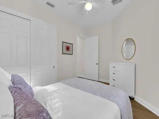 a bedroom with a bed a mirror and a window