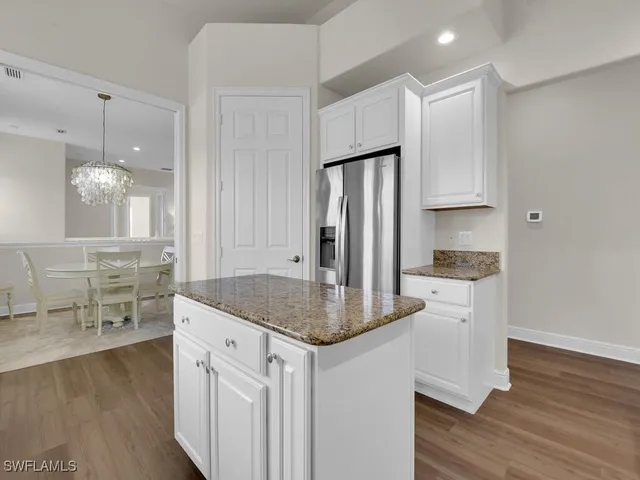 a kitchen with stainless steel appliances granite countertop a sink refrigerator and cabinets
