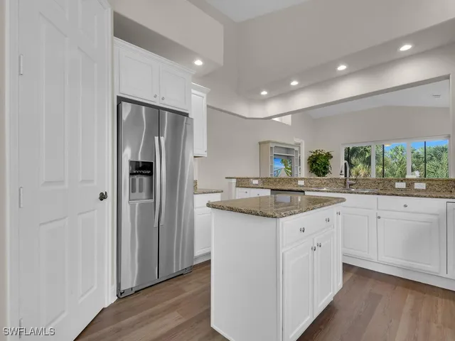 a kitchen with granite countertop appliances a sink and cabinets