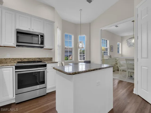 a kitchen with stainless steel appliances granite countertop a stove and a microwave