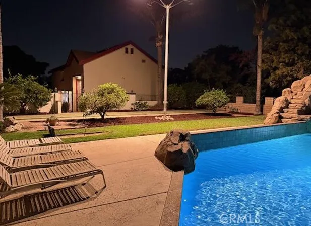 a view of a yard with potted plants and large trees