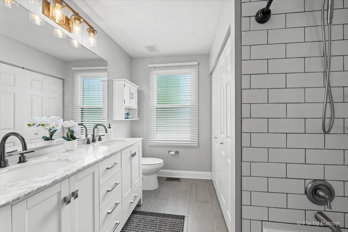 1150 Appleton Lane Geneva, IL 60134 - Photo 4 of 43 a bathroom with a double vanity sink a toilet a mirror and shower