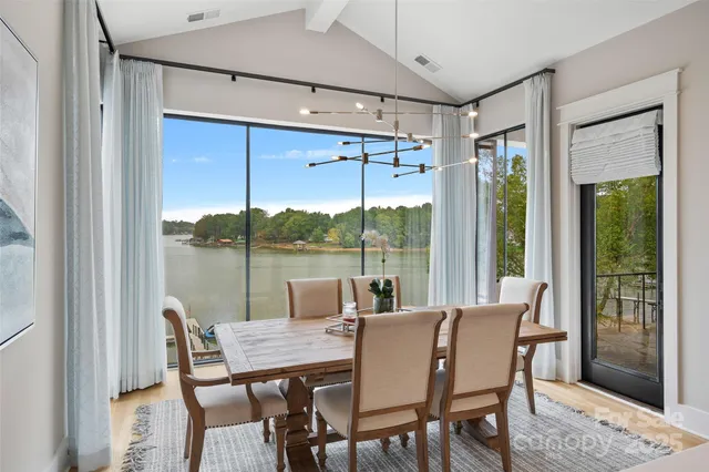 a dining room with furniture large windows and a chandelier