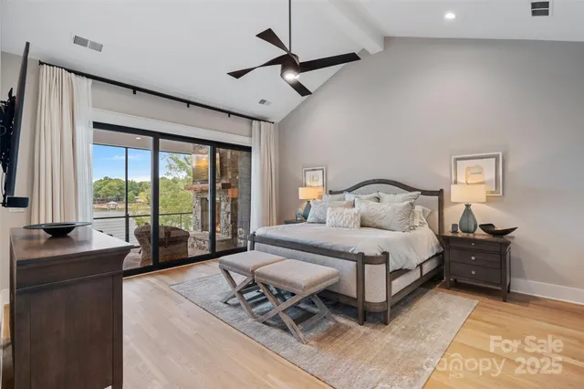 a bedroom with a bed and large windows