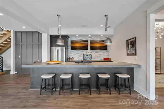 a kitchen with a dining table chairs cabinets and stainless steel appliances