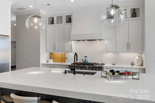 a kitchen with a sink a cabinets and chairs