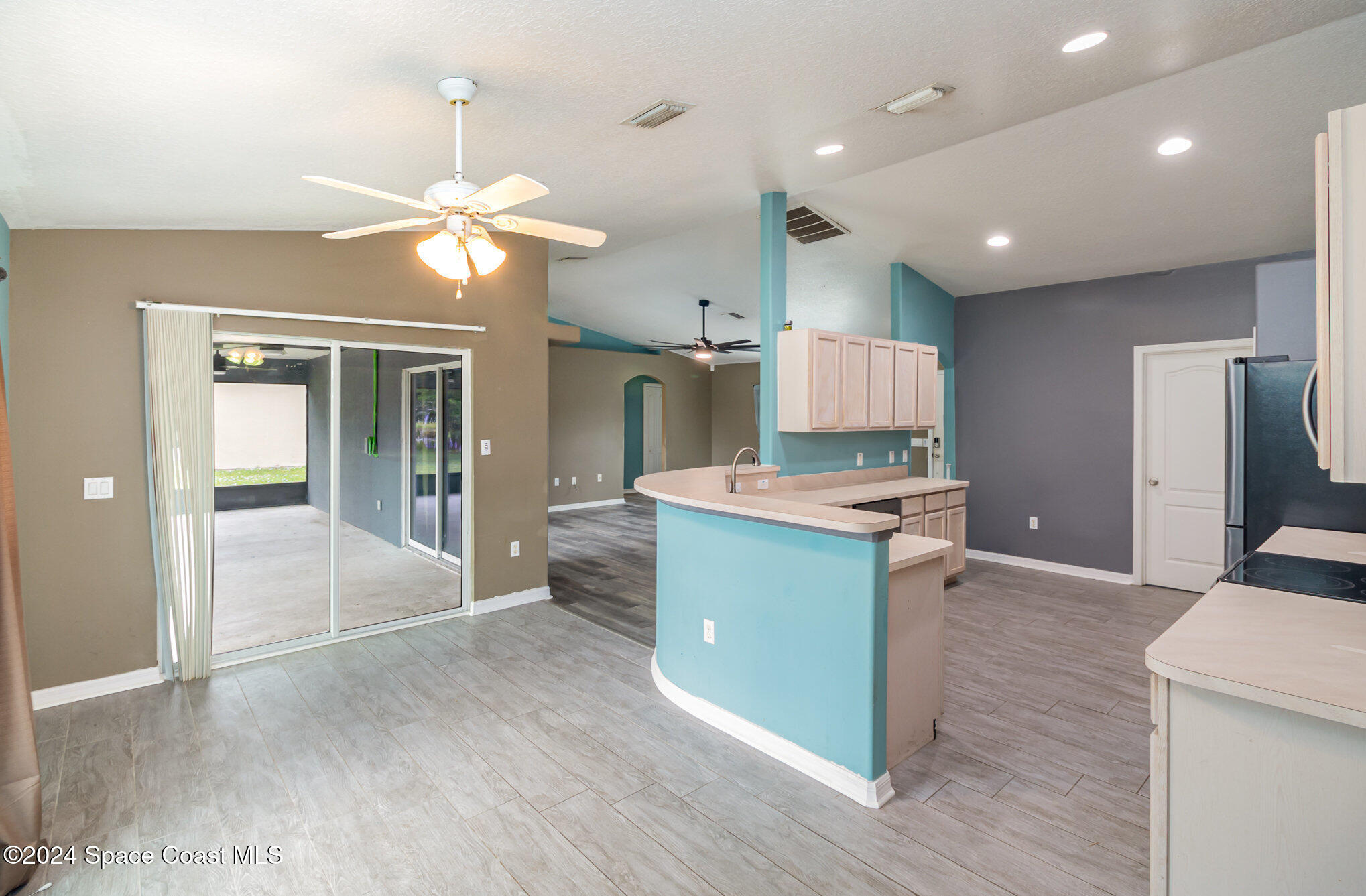 1223 Winding Meadows Road Rockledge, FL 32955 - Photo 12 of 27 a kitchen with kitchen island a counter top space appliances and a ceiling fan