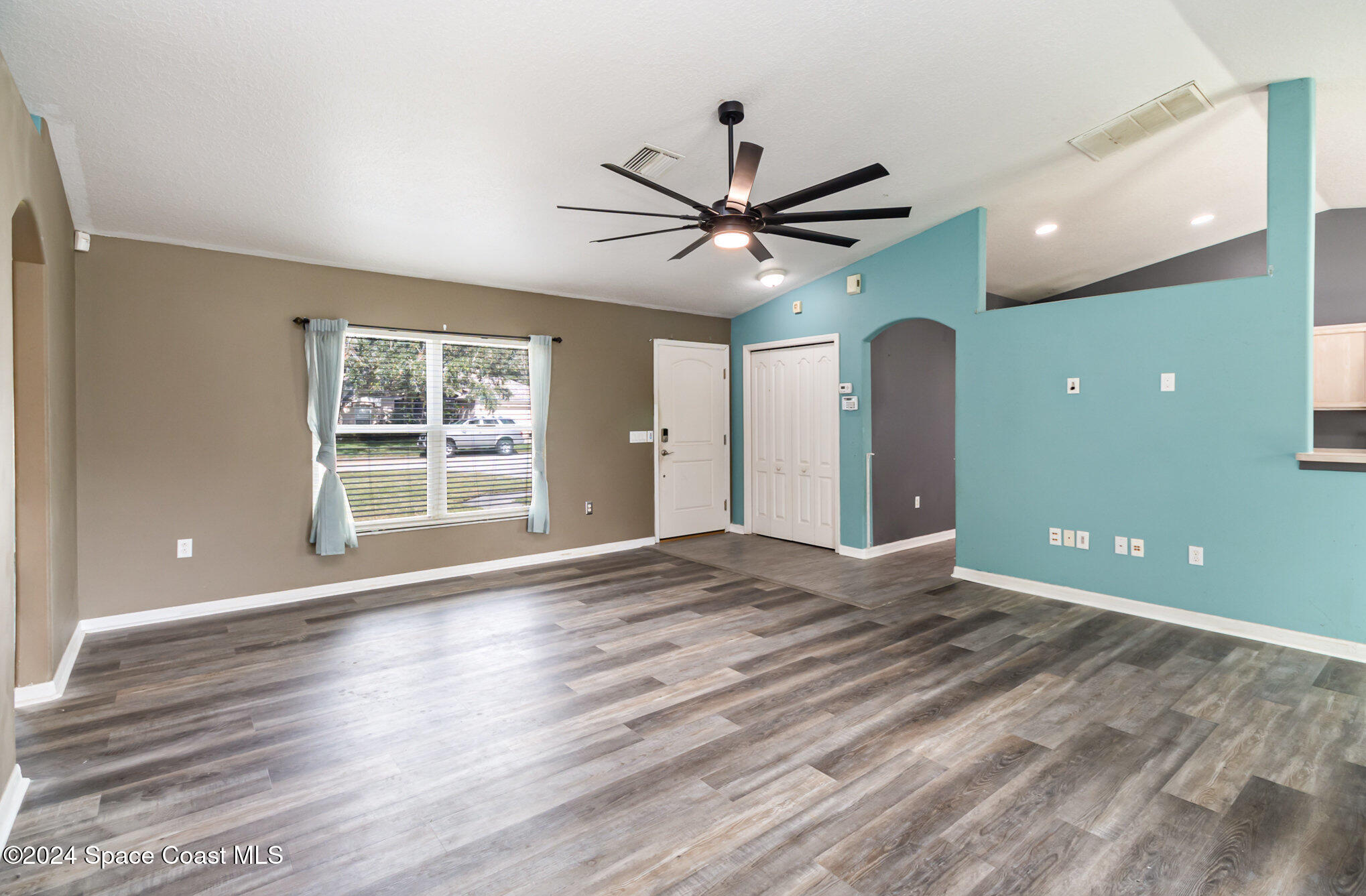 1223 Winding Meadows Road Rockledge, FL 32955 - Photo 5 of 27 a view of an empty room with a window and wooden floor