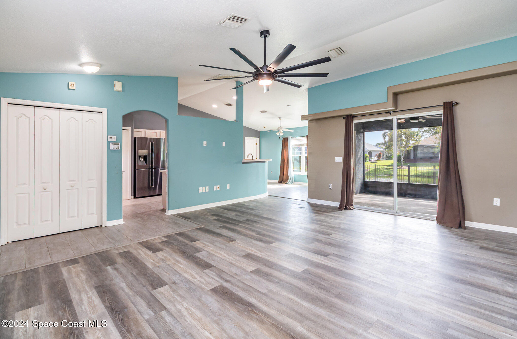 1223 Winding Meadows Road Rockledge, FL 32955 - Photo 6 of 27 wooden floor in an empty room with a window
