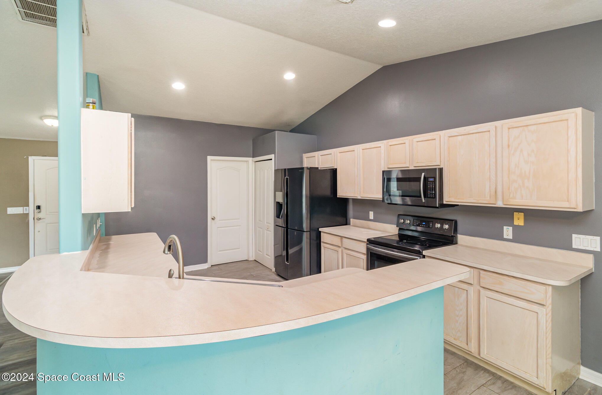 1223 Winding Meadows Road Rockledge, FL 32955 - Photo 8 of 27 a kitchen with stainless steel appliances a refrigerator sink stove microwave and cabinets