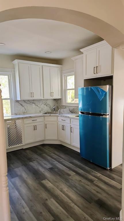 69 Saddle River Road, Unit #1 Monsey, NY 10952 - Photo 7 of 7 Kitchen with white cabinetry, sink, decorative backsplash, stainless steel refrigerator, and dark hardwood / wood-style floors