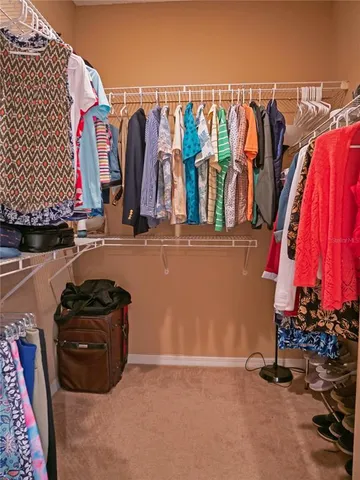 a view of walk in closet with clothes and shoes