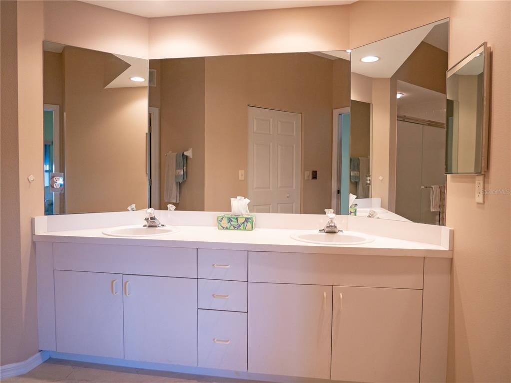 6401 99th Way North, Unit 15C St. Petersburg, FL 33708 - Photo 25 of 48 a bathroom with a double vanity sink and mirror