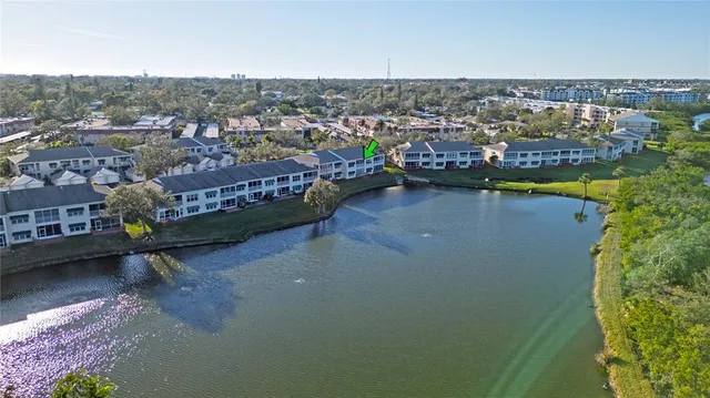 an aerial view of a city with lots of residential buildings ocean and mountain view in back