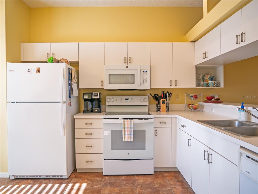 6401 99th Way North, Unit 15C St. Petersburg, FL 33708 - Photo 6 of 48 a kitchen with cabinets appliances a sink and a counter top