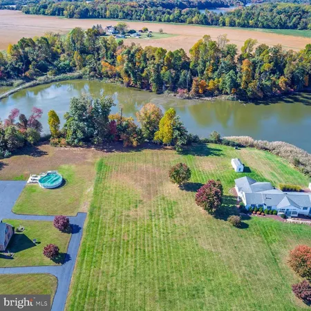 an aerial view of residential houses with outdoor space and lake view