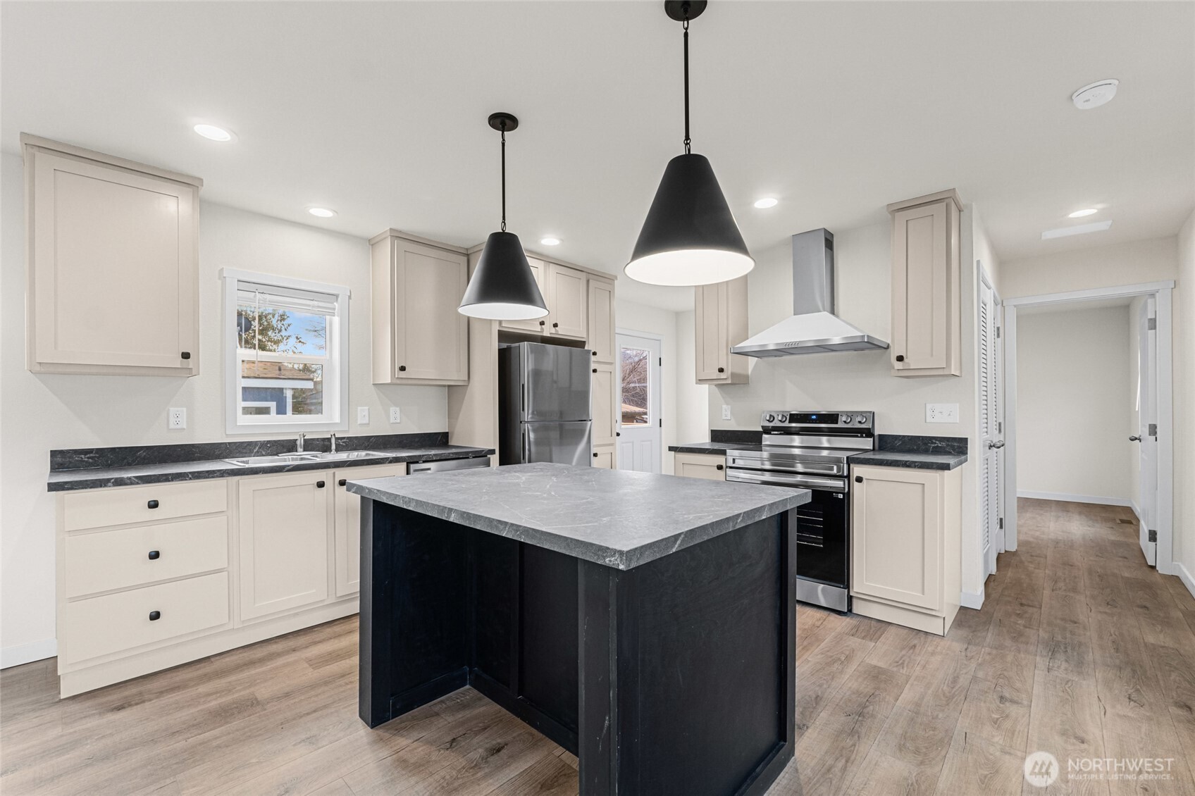 793 North Carter Street Colville, WA 99114 - Photo 3 of 19 a kitchen with stainless steel appliances a sink a stove a refrigerator and white cabinets