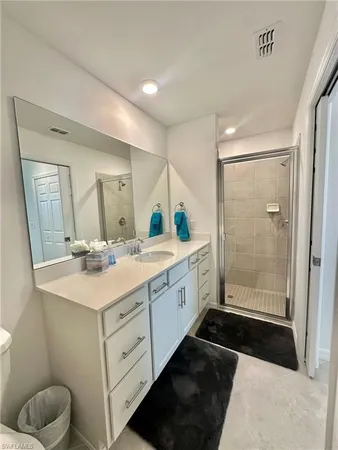 a bathroom with a double vanity sink a toilet and a shower