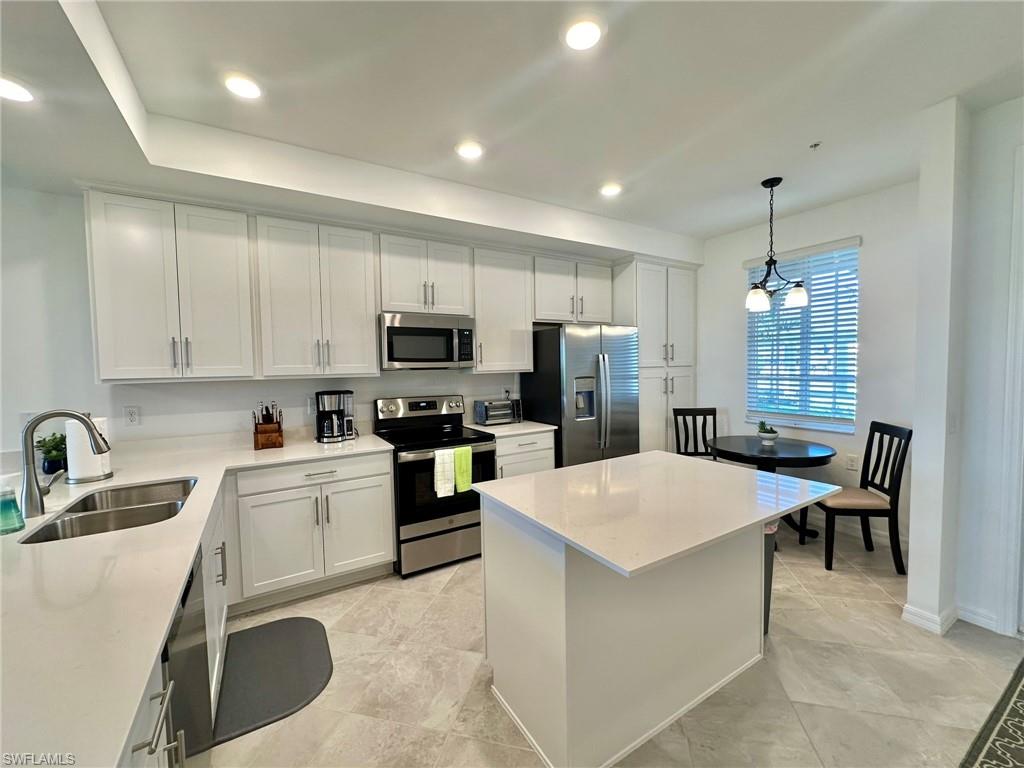 43985 Boardwalk Loop, Unit 2115 Babcock Ranch, FL 33982 - Photo 8 of 42 a kitchen with a sink a stove a refrigerator cabinets and a dining table