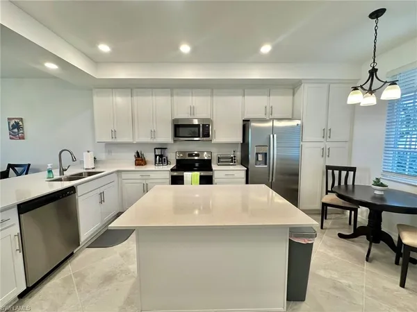 a kitchen with stainless steel appliances a refrigerator sink and microwave