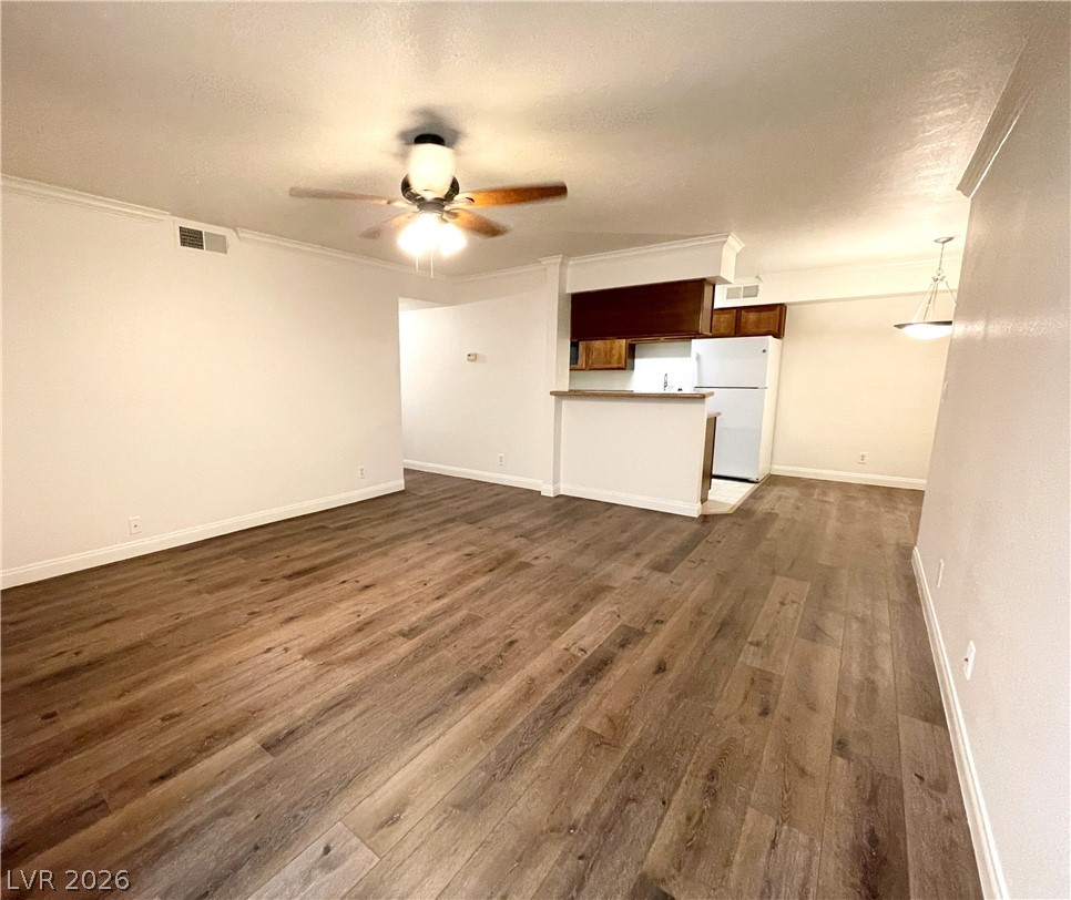 3135 South Mojave Road, Unit 221 Las Vegas, NV 89121 - Photo 3 of 19 A combined living area and kitchen with rich wood flooring creates a welcoming, cohesive space.