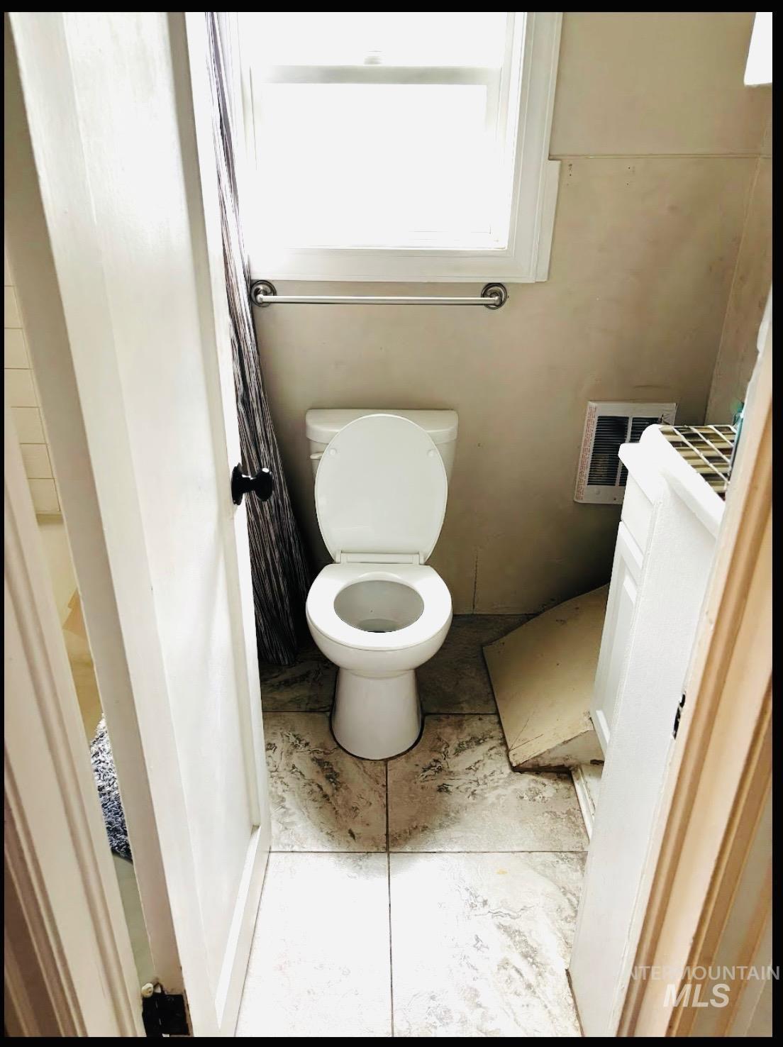 409 North 7th Street Payette, ID 83661 - Photo 14 of 23 Ceramic tile flooring with a white toilet and a window above